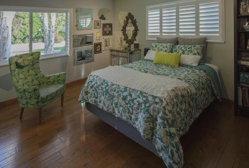 a bedroom with a bed and a chair and windows at Artistic Resort Like Home with Pool in Fullerton