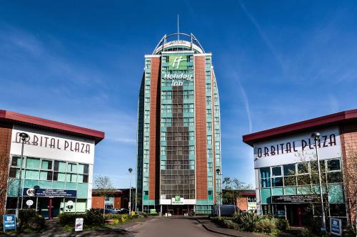 a tall building with a clock on the top of it at Holiday Inn Birmingham North - Cannock by IHG in Cannock