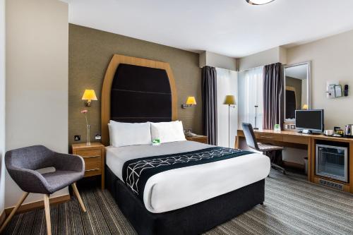 a hotel room with a bed and a desk at Holiday Inn Birmingham North - Cannock, an IHG Hotel in Cannock