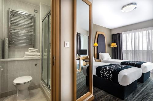a hotel room with two beds and a bathroom at Holiday Inn Birmingham North - Cannock, an IHG Hotel in Cannock