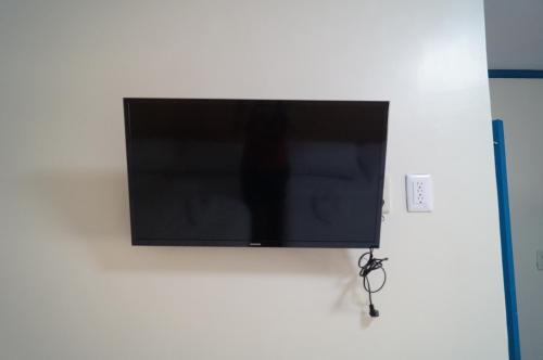 a flat screen tv hanging on a wall at Camiguin VIAJEROS House Rental in Compol