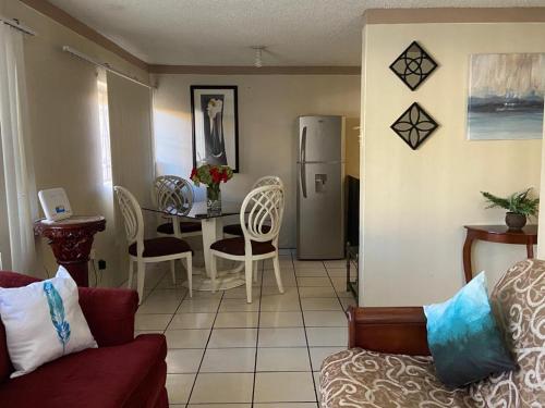 a living room with a couch and a table with a refrigerator at Departamento Bahia in Ensenada