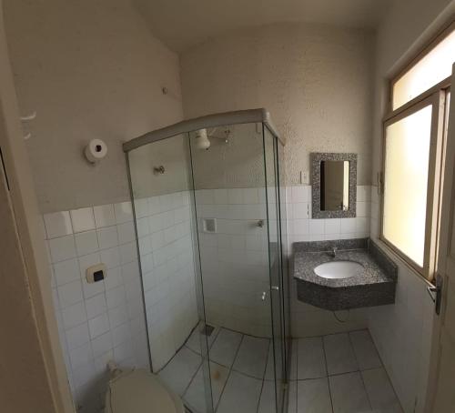 y baño con ducha y lavamanos. en HOTEL CARMO PALACE, en Carmo do Paranaíba