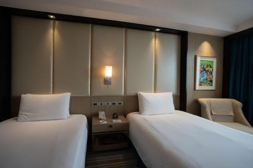 a hotel room with two beds and a chair at Marco Polo Plaza Cebu in Cebu City