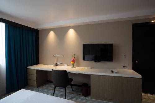 a room with a desk with a television and a chair at Marco Polo Plaza Cebu in Cebu City