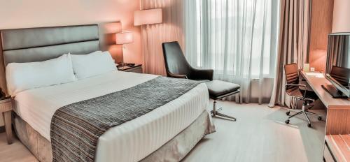 a hotel room with a bed and a desk and a television at Holiday Inn Bucaramanga Cacique by IHG in Bucaramanga