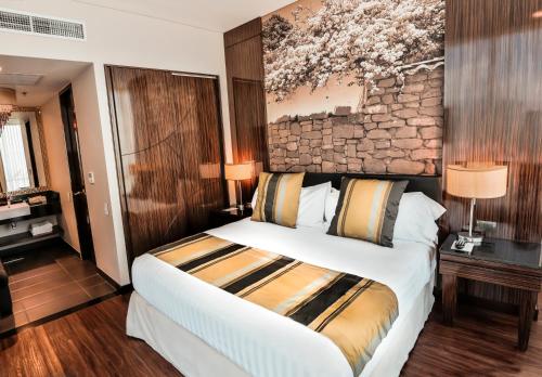 a bedroom with a large bed and a painting on the wall at Holiday Inn Bucaramanga Cacique by IHG in Bucaramanga