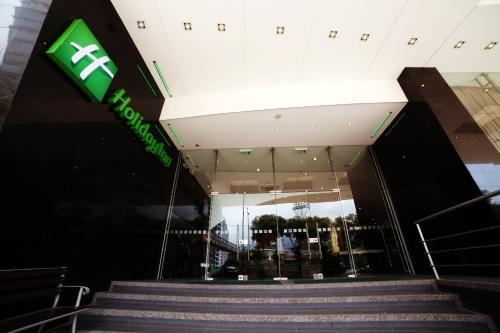 an entrance to a building with a green sign at Holiday Inn Bucaramanga Cacique by IHG in Bucaramanga