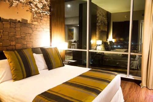 a bedroom with a bed with a large window at Holiday Inn Bucaramanga Cacique by IHG in Bucaramanga
