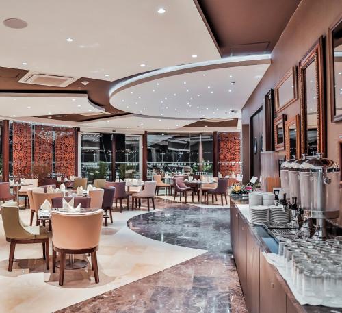 a restaurant with tables and chairs and windows at Holiday Inn Bucaramanga Cacique by IHG in Bucaramanga
