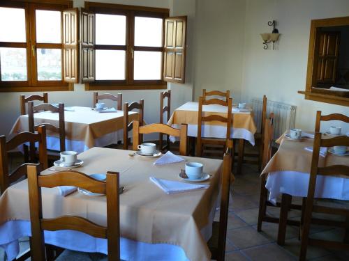 a restaurant with tables and chairs with white table cloth at Casa Rural El Rincón de Elena in San Esteban de Gormaz