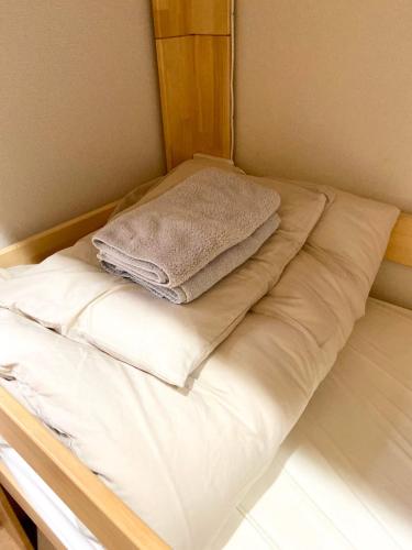 a bed with white sheets and towels on it at Upper Hotel Ryogoku in Tokyo