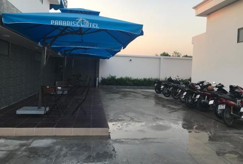 a row of motorcycles parked next to a building with an umbrella at Paradise Hotel in Củ Chi