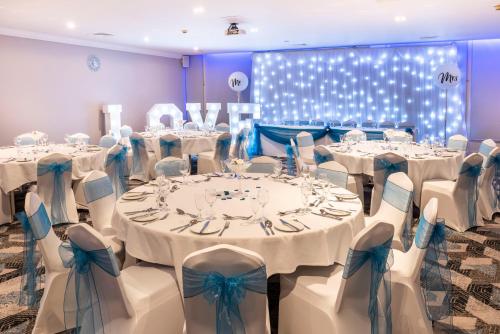 a room with white tables and chairs with blue bows at Holiday Inn Birmingham M6, Jct7 by IHG in Birmingham