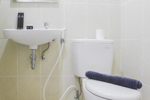 a bathroom with a white toilet and a sink at New Furnished Studio Apartment at M-Town Residence By Travelio in Pumpangsineng