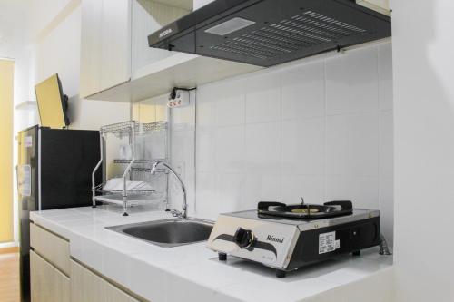 a kitchen with a sink and a stove at New Furnished Studio Apartment at M-Town Residence By Travelio in Pumpangsineng
