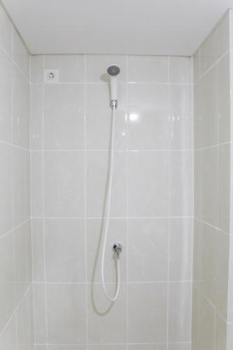 a white shower with a shower head in a bathroom at New Furnished Studio Apartment at M-Town Residence By Travelio in Pumpangsineng