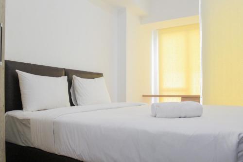 a bedroom with a large white bed with a window at New Furnished Studio Apartment at M-Town Residence By Travelio in Pumpangsineng
