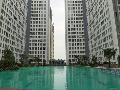 a large pool of water in front of tall buildings at New Furnished Studio Apartment at M-Town Residence By Travelio in Pumpangsineng
