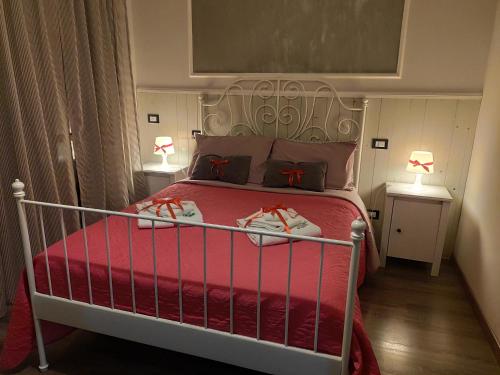 a bedroom with a bed with red sheets and shoes on it at Sweet Rome B&B in Rome
