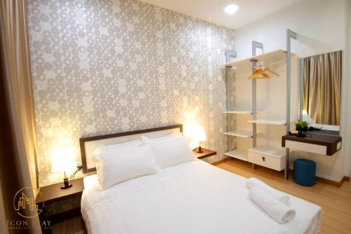 une chambre avec un lit blanc et un mur dans l'établissement The Wave Residence Melaka, à Malacca