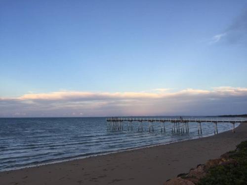 a beach with a pier in the water at Holiday on Hillcrest in Scarness