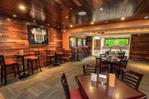 a restaurant with wooden walls and tables and chairs at Holiday Inn Leon by IHG in León