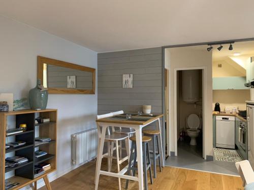 uma cozinha com mesa e cadeiras num quarto em Le Solidor vue mer em Saint Malo