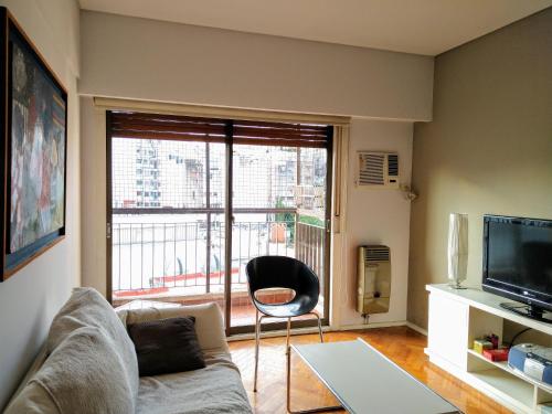 sala de estar con sofá, silla y TV en Cozy apartment in Recoleta I en Buenos Aires
