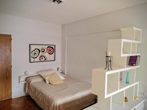 Dormitorio blanco con cama y estante en Cozy apartment in Recoleta I en Buenos Aires