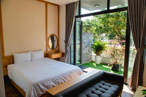 a bedroom with a bed and a large window at Minh Hung Apartment & Hotel in Danang