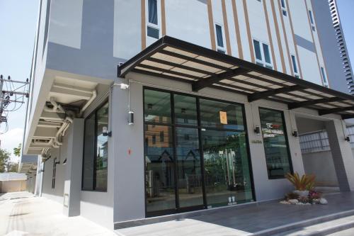 a building with large glass windows on a street at SC Residences in Suratthani