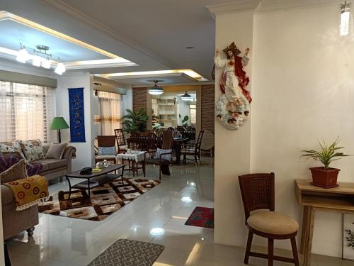 - un salon avec un canapé, une table et des chaises dans l'établissement AJ's Haven Homestay, à Cebu