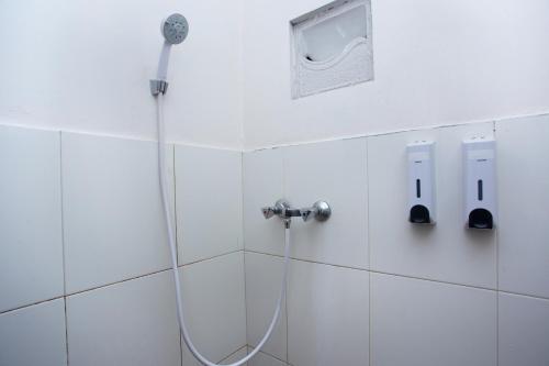 y baño con ducha con cabezal de ducha. en Super OYO 3042 Griya Karangsalam Indah, en Purwokerto