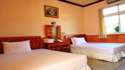 六龜區的住宿－寶來蘇羅婆渡假村，客房设有两张床、镜子和窗户。