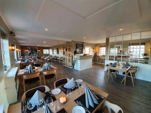 a dining room with tables and chairs in a restaurant at Hotel Nor - Badehotellet in Fjerritslev