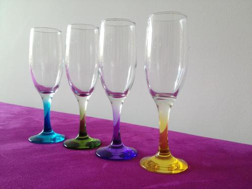 four wine glasses sitting on top of a purple table at Hotel Corbie Geel in Geel