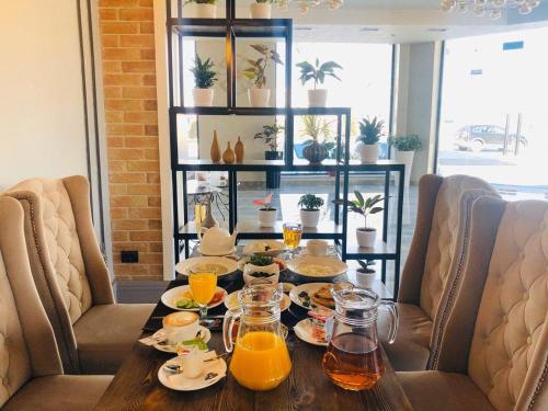 a dining room table with glasses of orange juice at Corner Hotel Tashkent in Tashkent