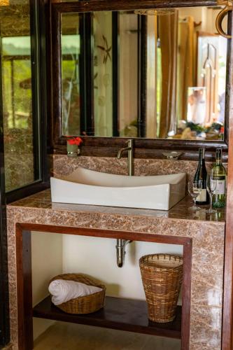 a bathroom counter with a sink and a mirror at Peak View Resort in San Vicente