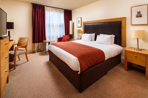 a hotel room with a large bed and a television at Holiday Inn Dumfries, an IHG Hotel in Dumfries