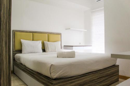 a bedroom with a large bed with white sheets at Relaxing 2BR Apartment at M-Town Residence By Travelio in Pumpangsineng