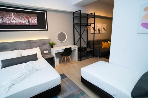 a bedroom with two beds and a tv on the wall at Revo Pavilion Bukit Jalil by Ody Suites in Kuala Lumpur