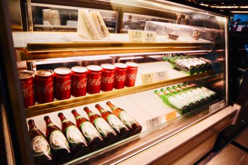 a refrigerator filled with bottles of soda and sushi at Shinkansen Grand Hotel in Taichung