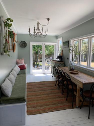 a dining room with a table and a couch at Cooper's Cottage in Nelson