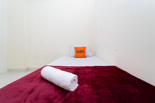 KoolKost @ Harapan Indah في بيكاسي: سرير ابيض مع بطانيه حمراء ومخده