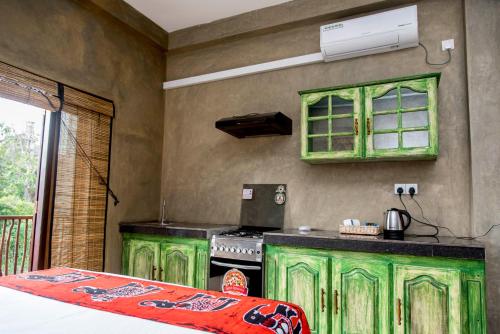 a green kitchen with a stove and green cabinets at Negombo Boutique Villa in Negombo