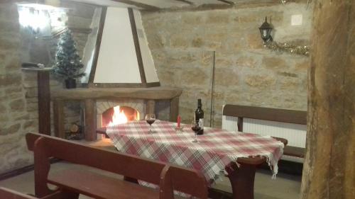 uma sala de jantar com uma mesa e uma lareira em Старата къща - Трявна em Tryavna