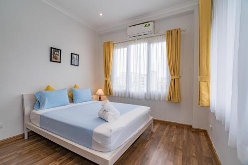 a bedroom with a bed with blue pillows and a window at WECOZY HANOI - Railway Side, The Old Quarter in Hanoi