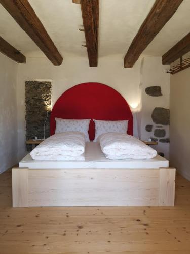 a bedroom with a large bed with a red headboard at Knappnhof in Campo di Trens