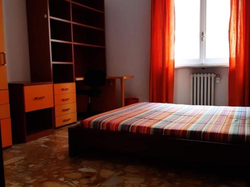 a bedroom with a bed and a dresser and a window at Appartamento Soleluna in Parma